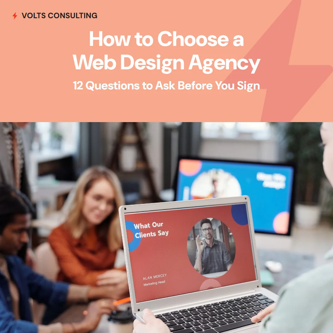 Business owners in a meeting reviewing a web design agency's presentation - the twelve questions to ask before signing